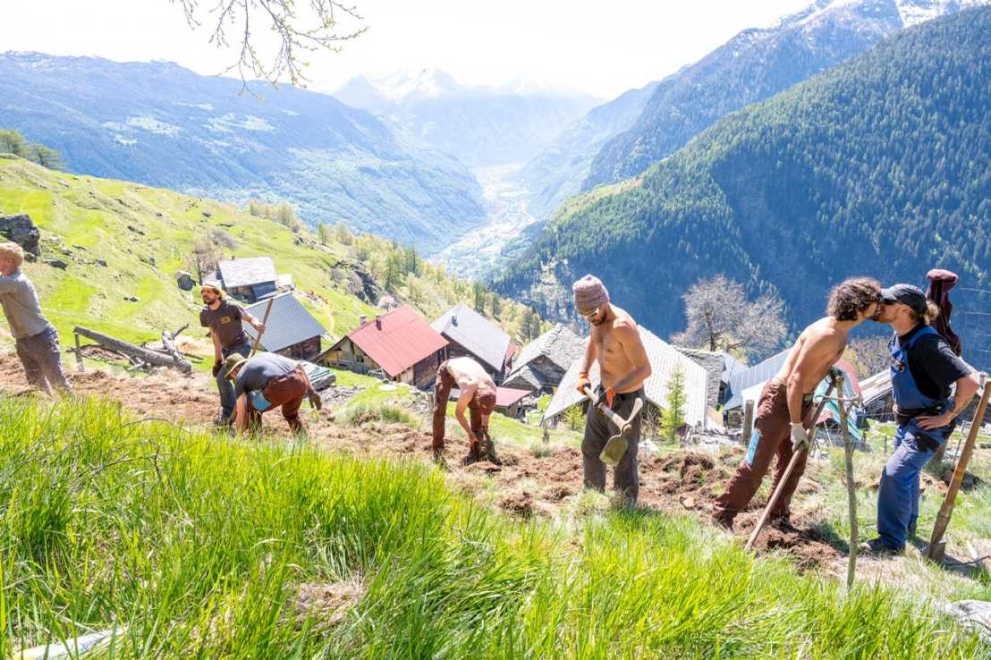 Männer mit Schaufeln auf Bergwiese