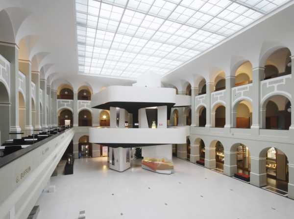 Heller Lichthof in historischem Gebäude mit modernem Ausstellungsturm