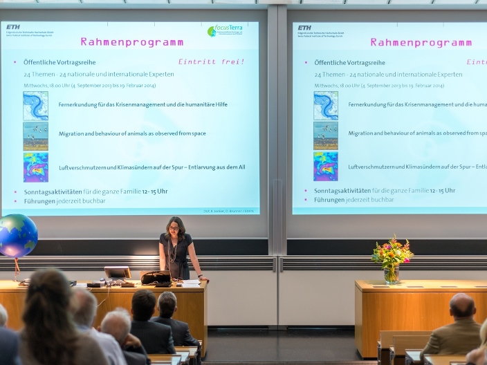 Dr. Ulrike Kastrup vor einer Leinwand mit Programm