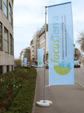 Vergrösserte Ansicht: Fahnen mit Schriftzug focusTerra auf Trottoir