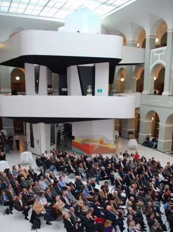Vergrösserte Ansicht: Der Ausstellungsturm im Hintergrund sitzender Zuhörer