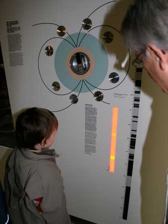 Vergrösserte Ansicht: Kind betrachtet die Magnetfeldumkehrunginstallation in der Ausstellung