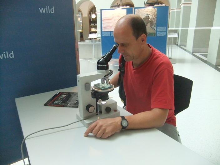 Besucher benützt das Mikroskop
