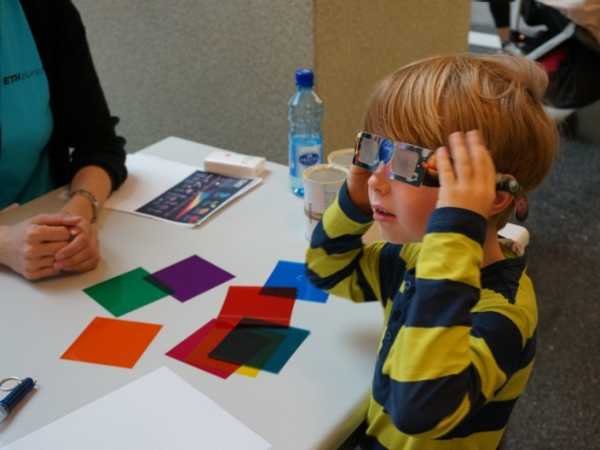 Vergrösserte Ansicht: Kind probiert Brille wird mit verschiedenen Farbfilter